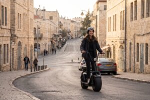 קורקינט חשמלי בירושלים בעלייה ברחוב עם אבן ירושלמית
